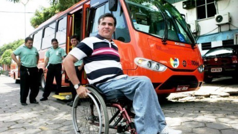 Uma pessoa cadeirante em frente a um micro-ônibus acessível. Foto: Eraldo Lopes - Acervo - DA