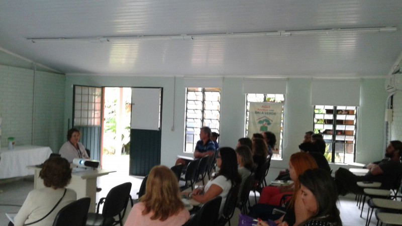 Capacitação interna para servidores do Cazon, onde todos estão sentados no auditório da Sala Verde e a palestrante Clarissa Beleza sentada a frente explanando sobre abordagem de jovens e adultos com Autismo. Crédito da Foto: divulgação.