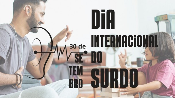 card Dia Internacional do Surdo - no fundo uma foto em transparência com um homem de pele clara e cabelos e barba castanho escuro, vestindo  camiseta e calça de abrigo cinza, sentado ao chão e fazendo um sinal em Libras, na sua frente um menino com pele clara, cabelos na altura dos ombros castanho escuro, camiseta em tom de vinho e bermuda jeans, entre os dois um brinquedo de montar, a criança também faz um sinal em Libras...escrito por cima em letras Pretas - 30 DE SETEMBRO - DIA INTERNACIONAL DO SURDO