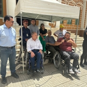 Na foto ao fundo o predio da Prefeitura de Porto Alegre, então em um toldo branco estão bem na frente, o presidente da Faders e sua cadeira de rodas com um microfone em mãos fazendo seu pronunciamento; ao seu lado a interprete de Libras da Faders, do outro o sec. Adjunto da Sec de Desenvolvimento Social de POA, e o vereador Alvoni Medina; atrás o jornalista que presentou o ceriomonial, ao seu lado o vereador Marcelo Bernardi, a representante da Defensoria Pública do RS, ao seu lado em sua cadeira de rodas o presidente do Coepede e a presidente do Comdepa em pé. Fim da Descrição 