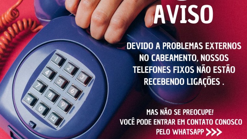 Card com fundo vermelho, no canto esquerdo ha um telefone azul fixo com uma mão segurando o gancho- do lado direito no topo a imagem de aviso e escrito em abaixo "AVISO"-  segue o texto: Devido a problemas externos no cabeamento, nossos telefones fixos não estão recebendo ligações-  Mas não se preocupe! Você pode entrar em contato conosco pelo Whatsapp. Abaixo ainda destes textosas as logos da Faders e da Sec. Desenvolvimento Social RS . Fim da descrição